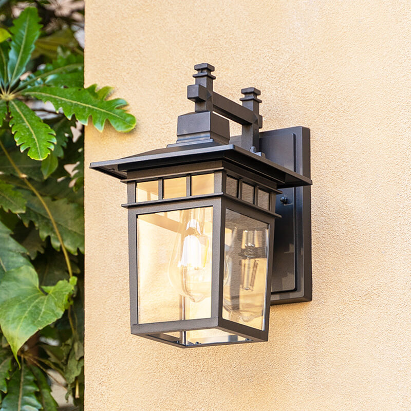 Close-up view of the black outdoor wall lantern illuminating a patio area