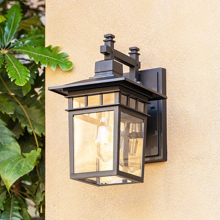 Close-up view of the black outdoor wall lantern illuminating a patio area
