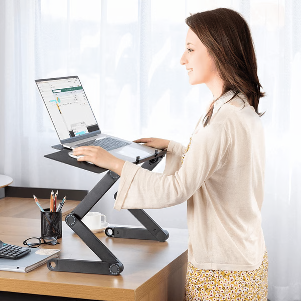 Woman standing while using a black adjustable laptop stand on a desk
