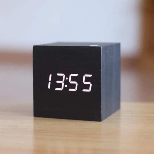 Modern black wooden digital LED cube clock showing time on desk