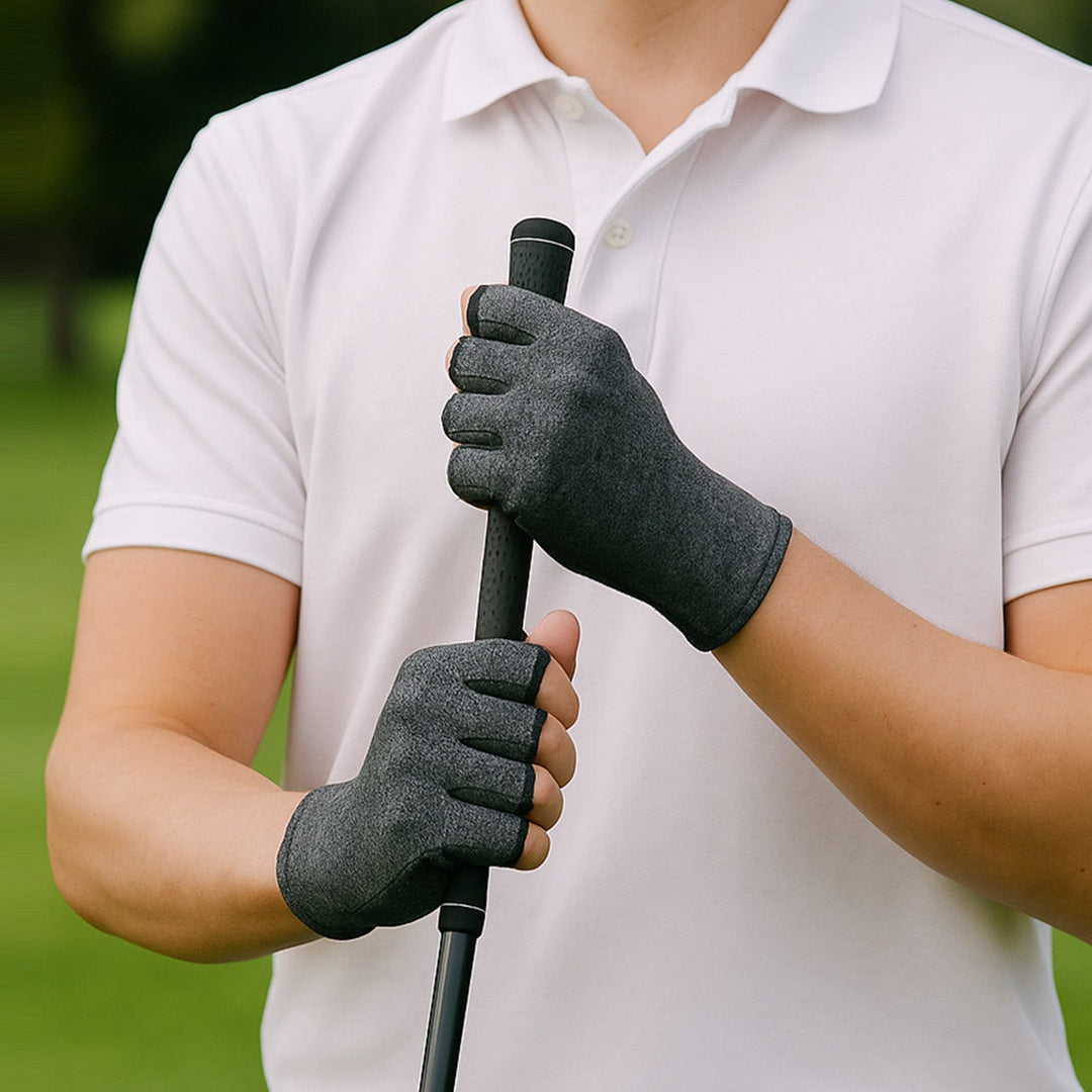 Person wearing grey therapeutic heat gloves while holding a golf club handle