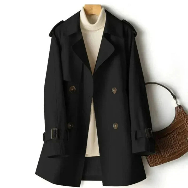 Black women's double-breasted trench coat hanging on hanger