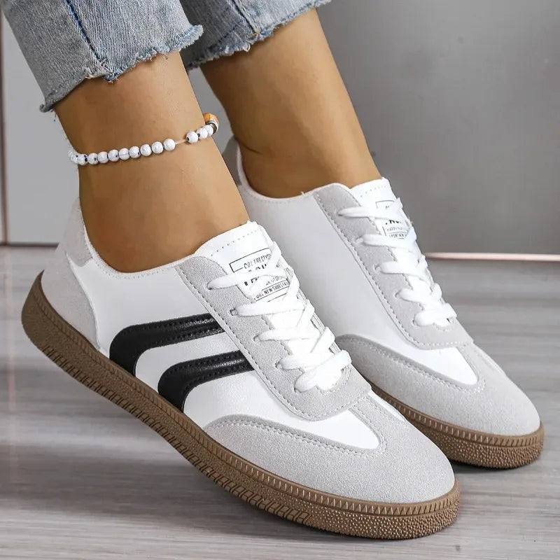 Women wearing black and white lace-up orthopedic sneakers with gum soles