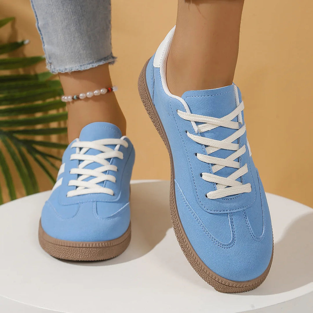 Blue casual lace-up sneakers displayed on a white round table