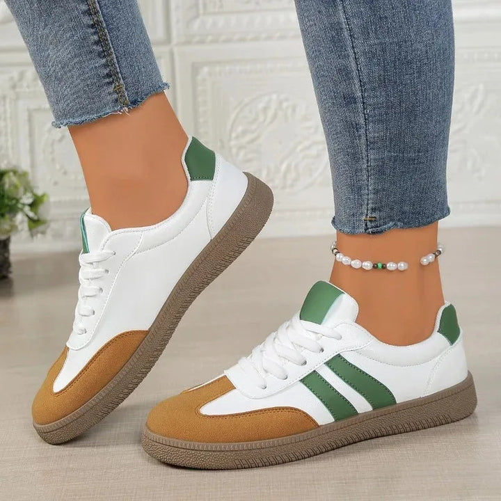 Green and white panelled orthopedic sneakers worn with denim jeans