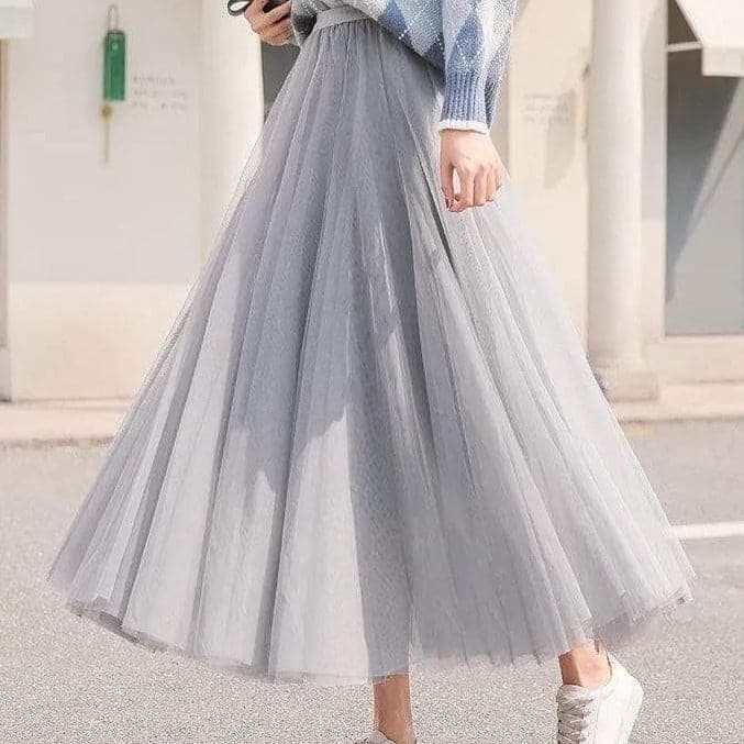 Woman wearing gray high waist pleated maxi skirt with white sneakers