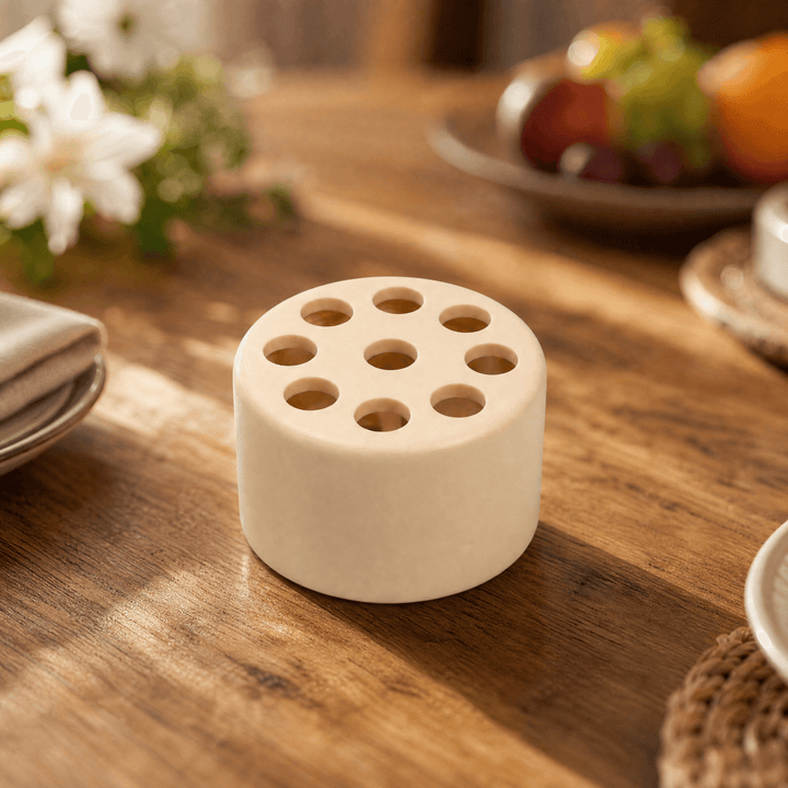 Beige small spiral flower arranger on a wooden table