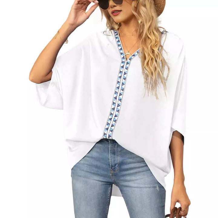Model wearing a white V-neck oversized embroidered tunic top with jeans