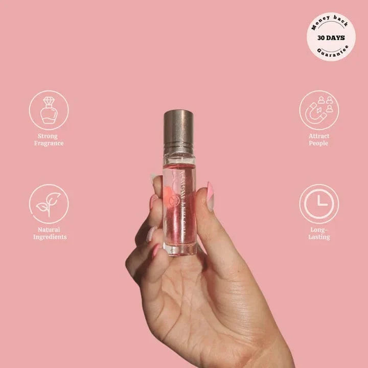 Hand holding Phero Perfume roll-on bottle with attraction and natural ingredient icons