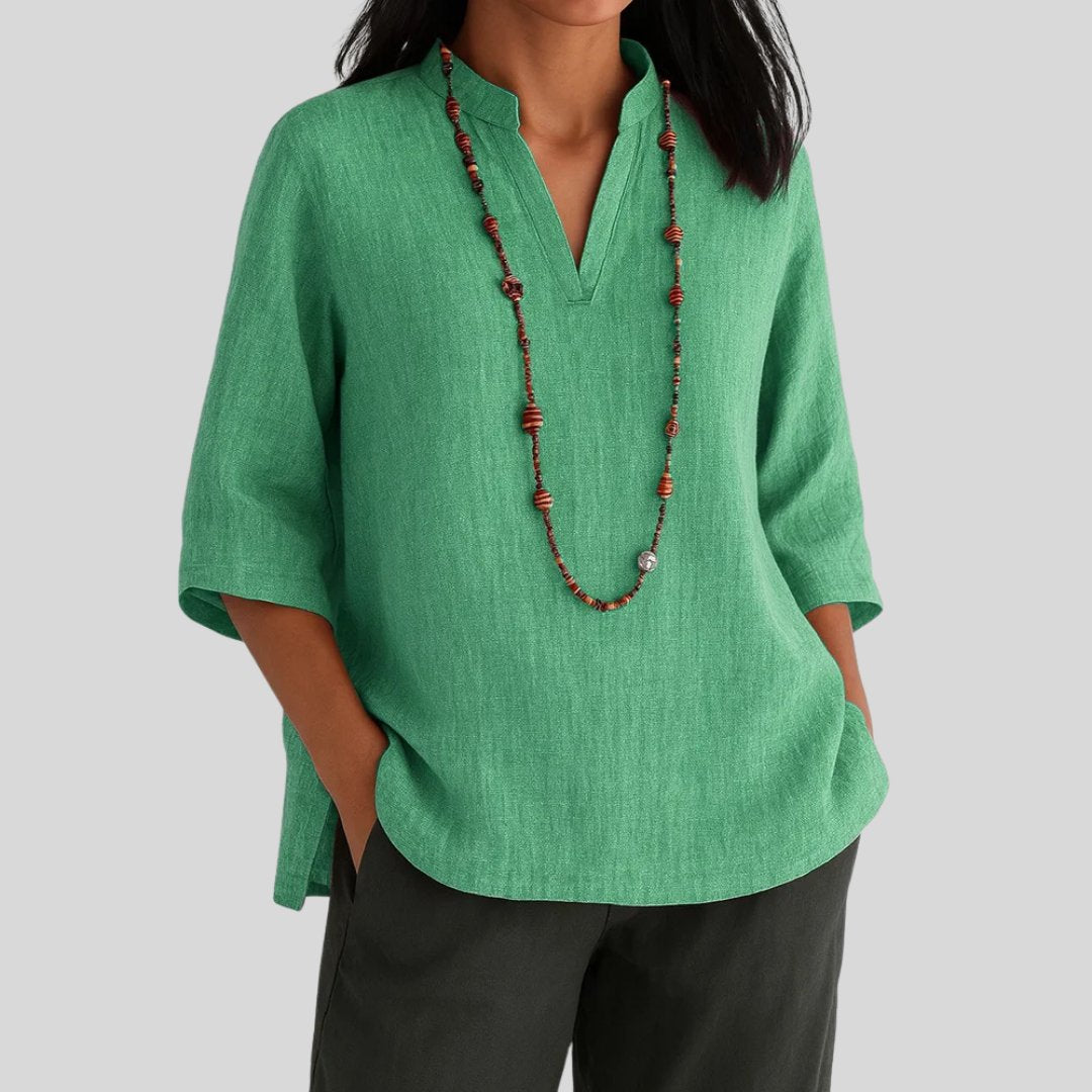 Woman wearing a relaxed green V-neck tunic top with three-quarter sleeves