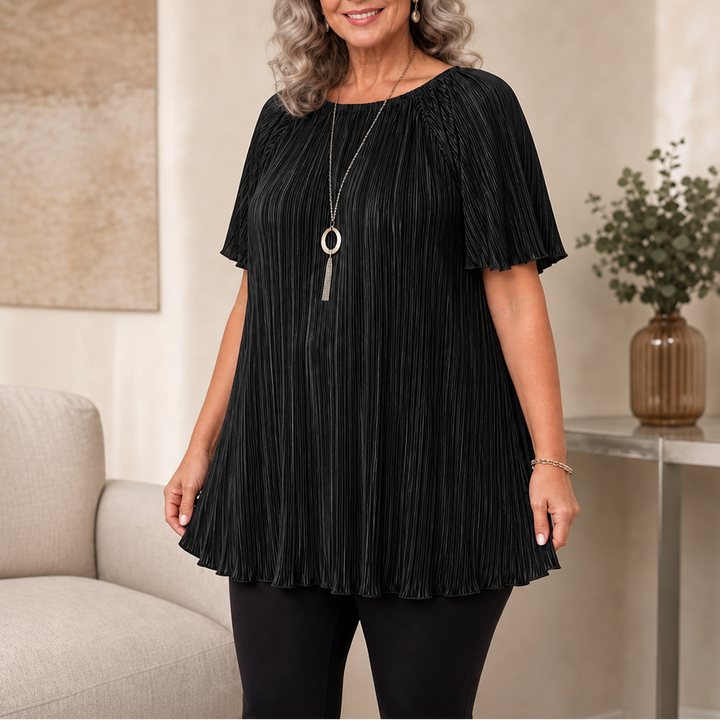 Woman wearing black pleated wide-fit blouse paired with black pants