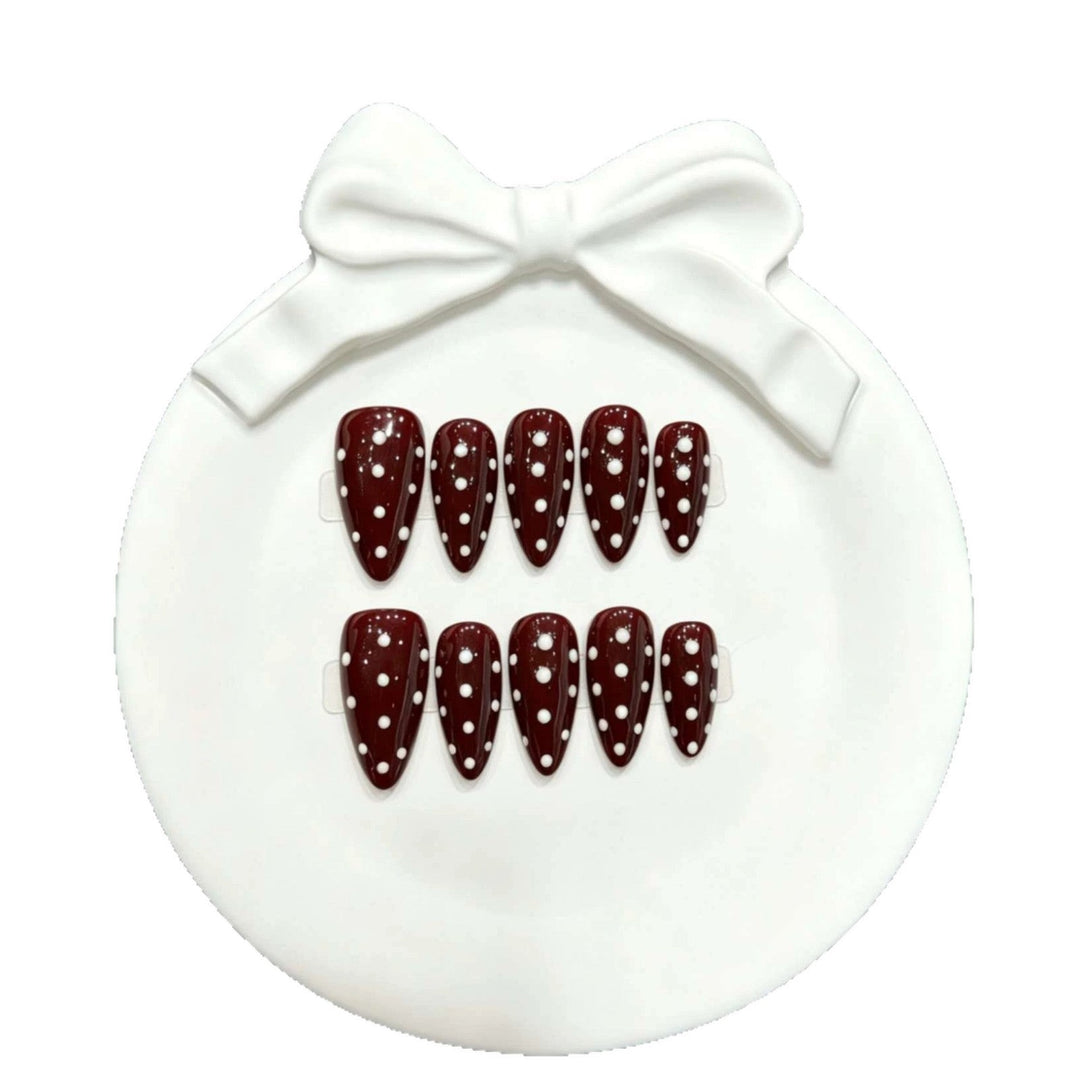 Close-up of stylish polka dot false nails and nail art accessories