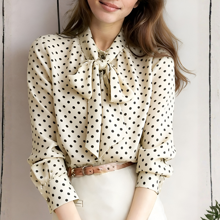 Model wearing an apricot polka dot tie-neck blouse