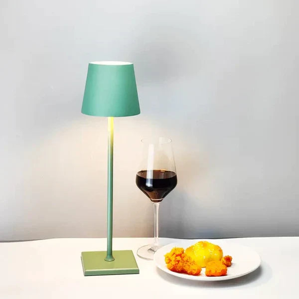 Green portable table lamp illuminating a cozy corner