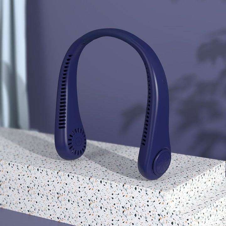 Deep blue portable neck fan resting on a stone surface