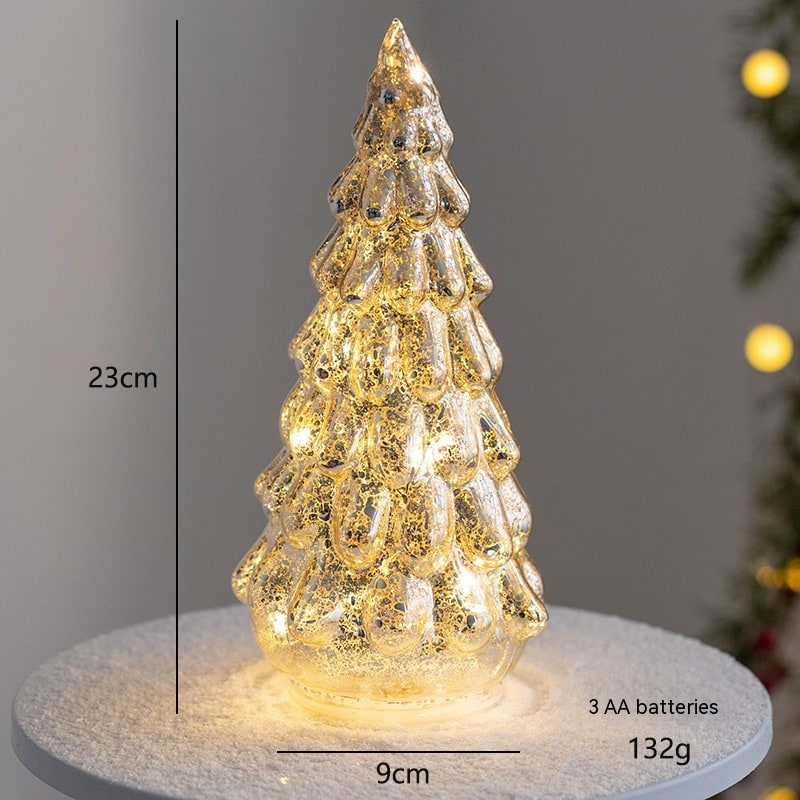 Warm glowing LED lights shining through a clear glass tabletop tree