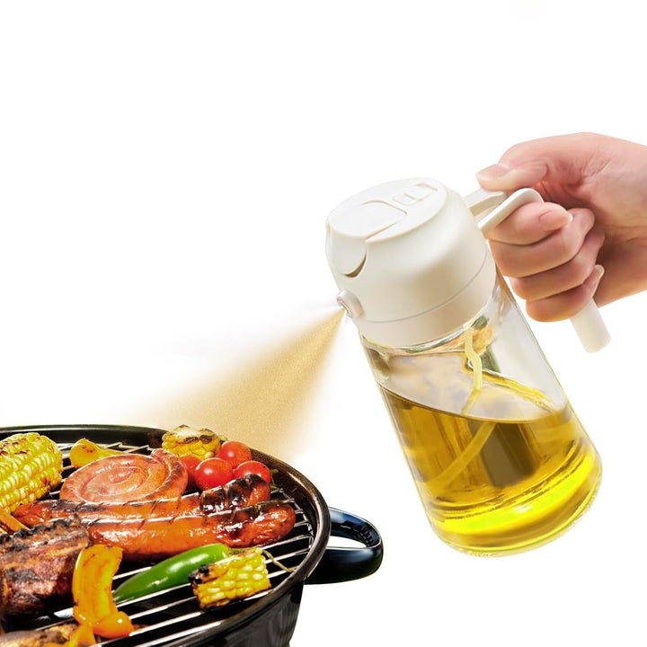 White 2-in-1 olive oil sprayer spraying mist over a grill
