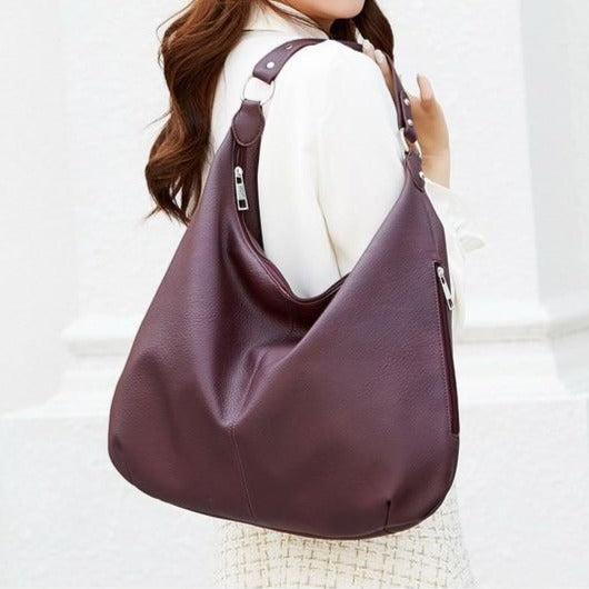Close up of luxury bag metallic zipper closure and branded pull detail