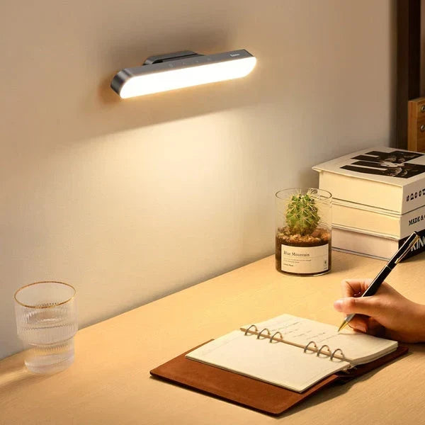 Magnetic LED desk lamp mounted above a wooden desk setup