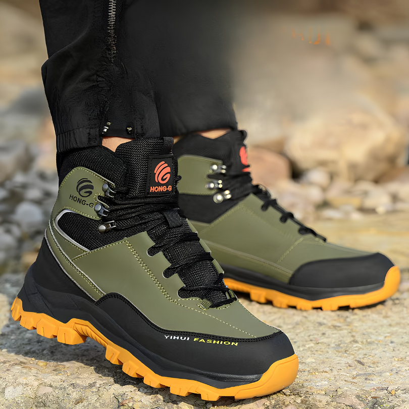 Green safety work boot worn outdoors on rocky terrain