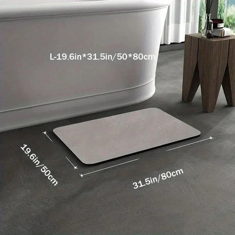 Gray rectangular quick-dry diatomite bath mat measuring 50x80 cm positioned on a modern dark tiled bathroom floor.