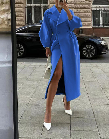 Woman wearing a bright blue double-breasted long coat posing outdoors