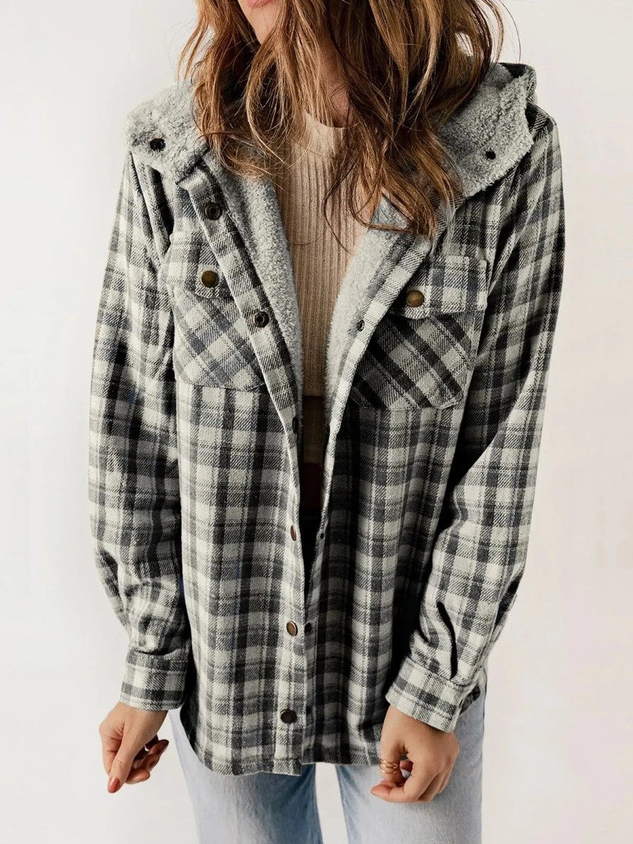 Woman wearing a dark grey hooded plaid jacket with button closure