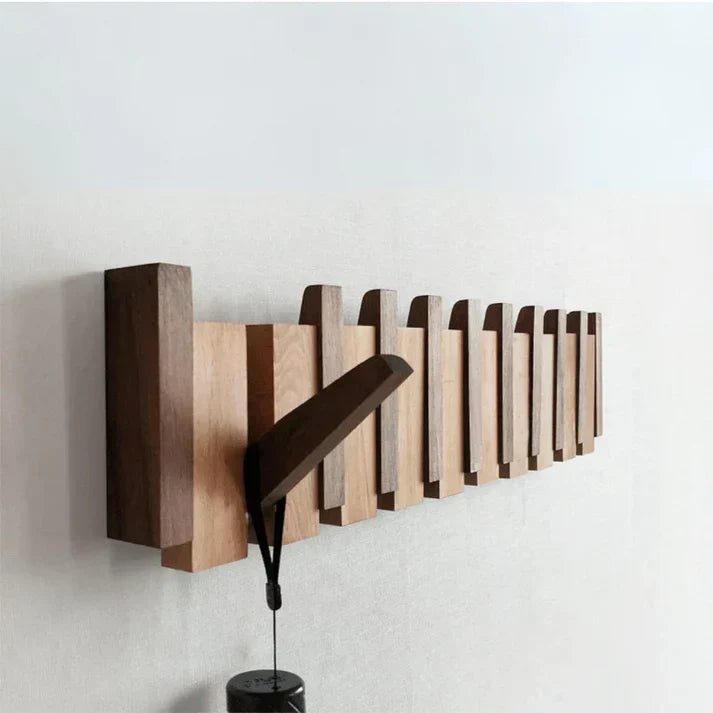 Wooden piano-style wall mounted coat rack showing retractable hooks in closed position