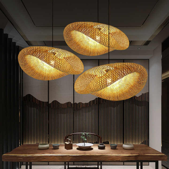 Handmade wavy rattan bamboo pendant light hanging over a wooden dining table