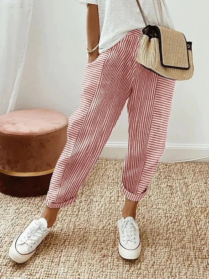 Woman wearing pink striped relaxed trousers paired with a white top
