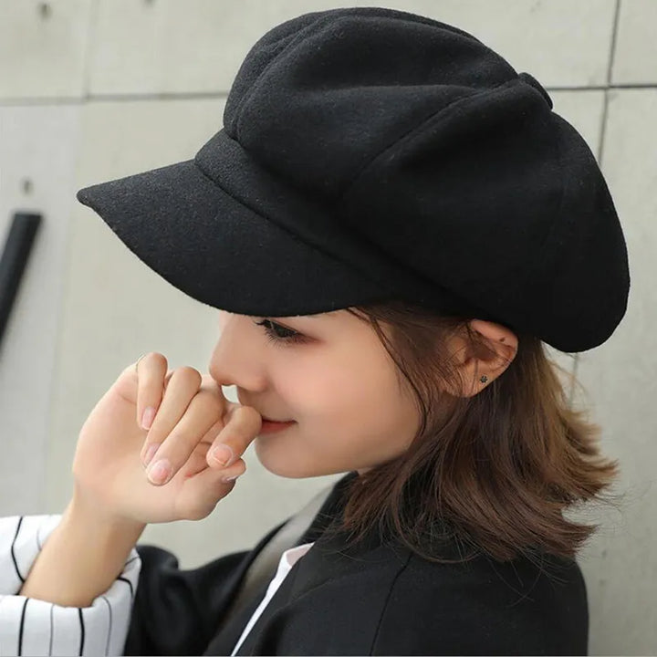 Woman wearing a black retro balloon hat in profile view
