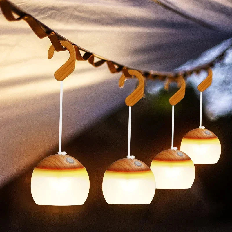 Retro camping lanterns hanging from a line inside a tent during evening