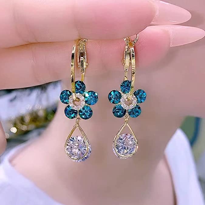 Close-up of blue floral crystal drop earrings being held