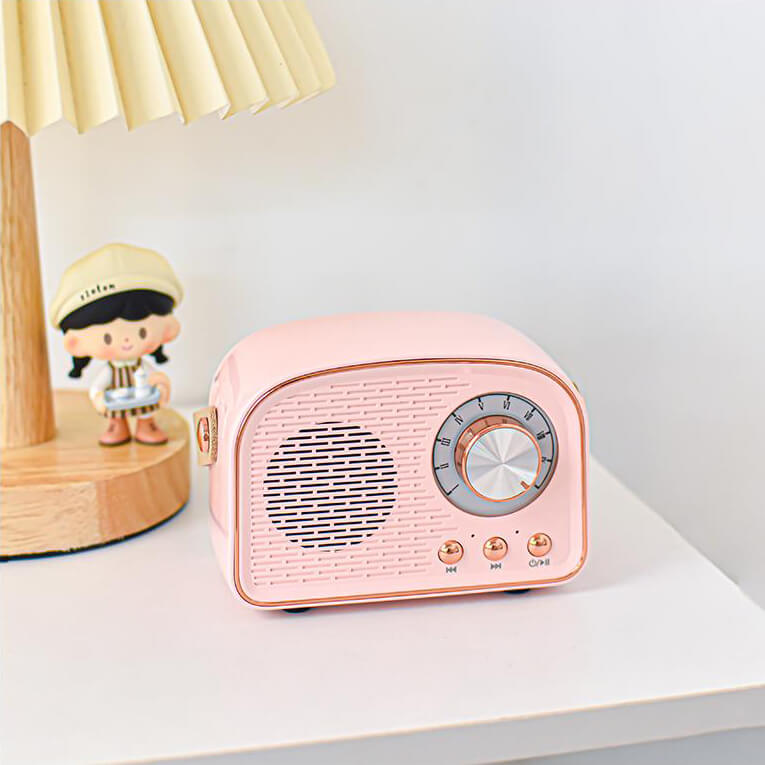 Pink retro Bluetooth speaker on a white desk