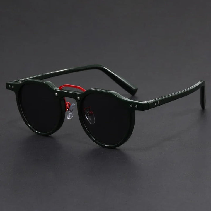 Dark framed retro sunglasses featuring a contrasting red bridge detail