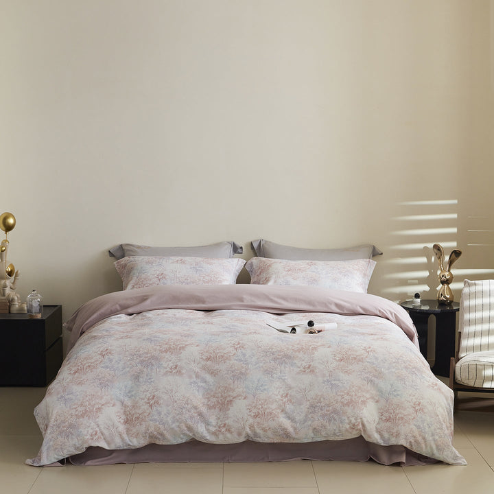 Reversible watercolor tree print bedding set with pink tones on a modern bed setup