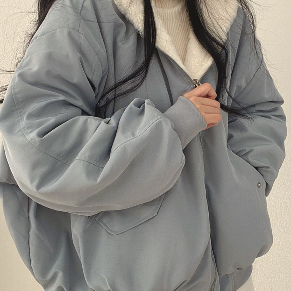 Women's reversible winter jacket in blue showing front zip closure and hood