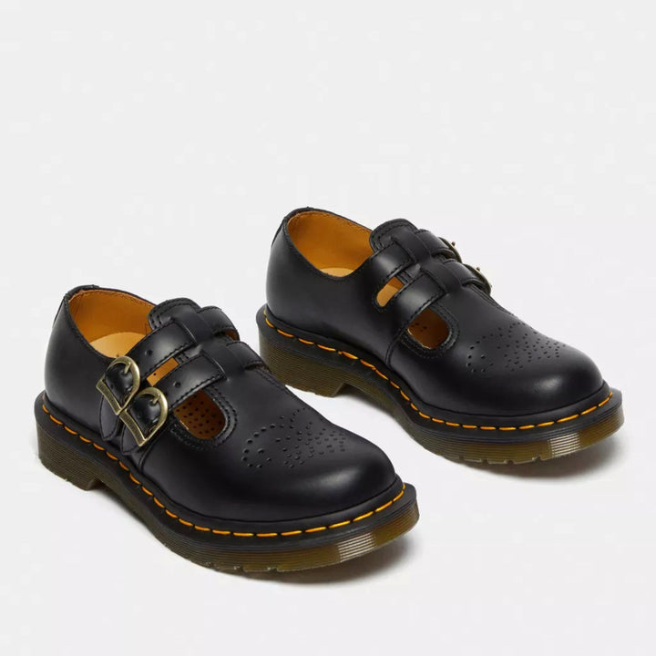Pair of women's black Mary Jane flats showing dual straps and heart perforation