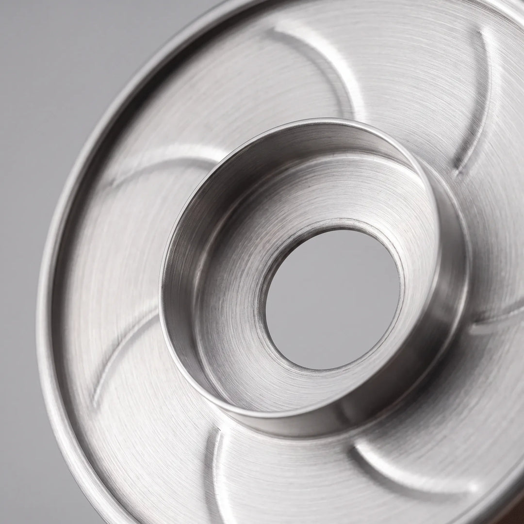 Stainless steel pour-over coffee dripper showing internal ribbed design for smooth flow