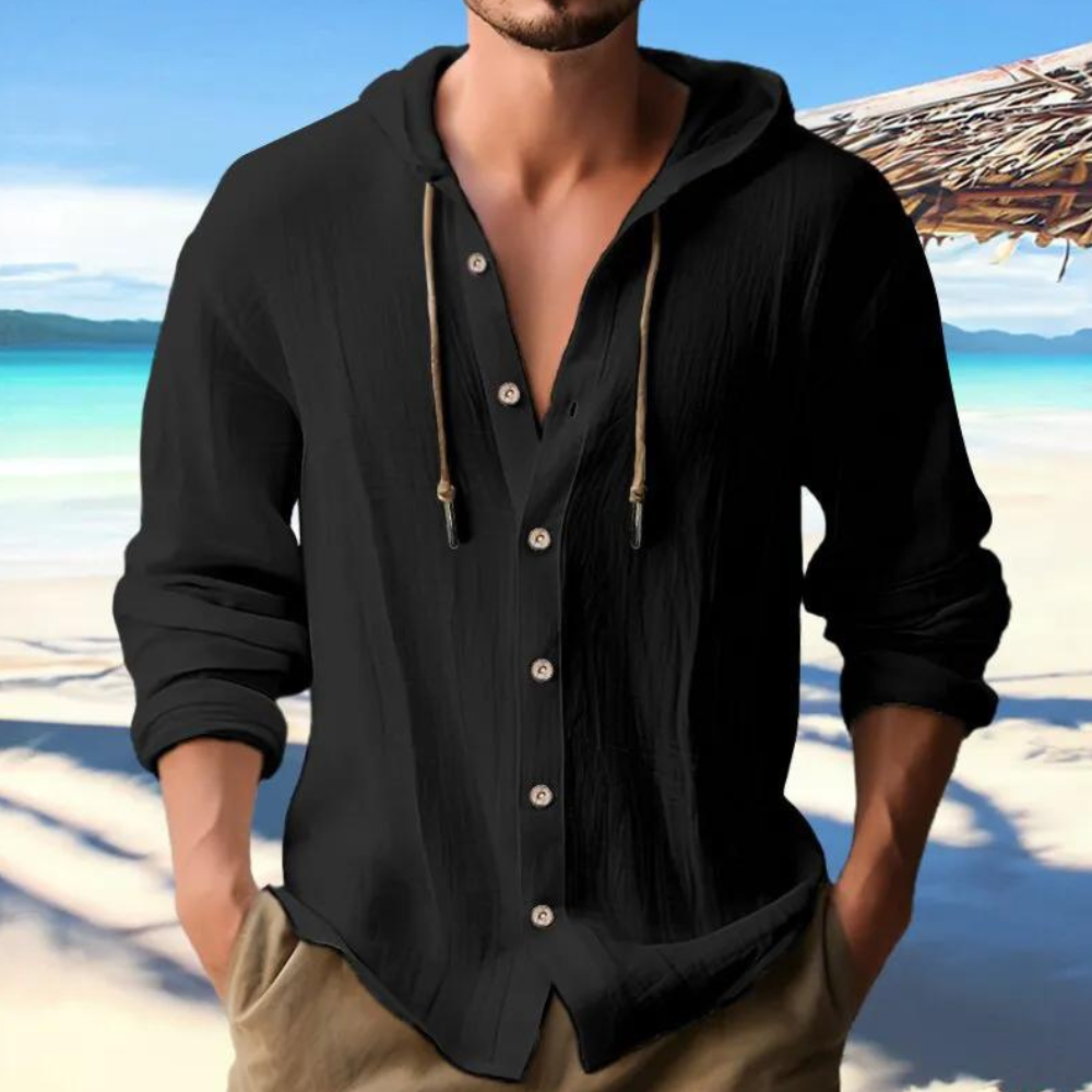 Men's black button-down hooded shirt styled with long sleeves against a beach backdrop.