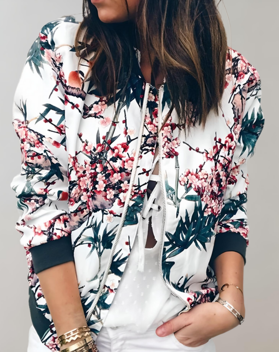 Woman wearing white floral zip-up bomber jacket with dark ribbed trim