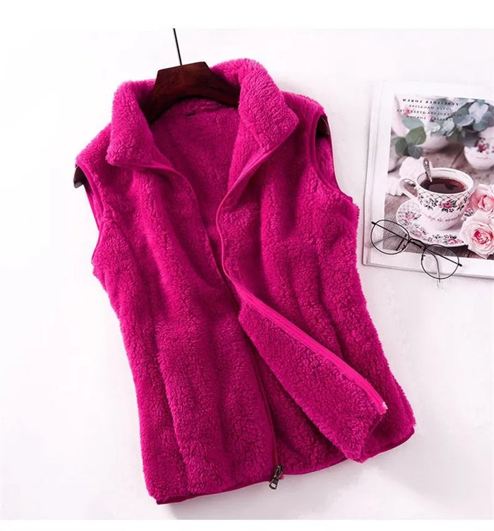 Vivid pink women's plush fleece gilet displayed with a magazine and teacup