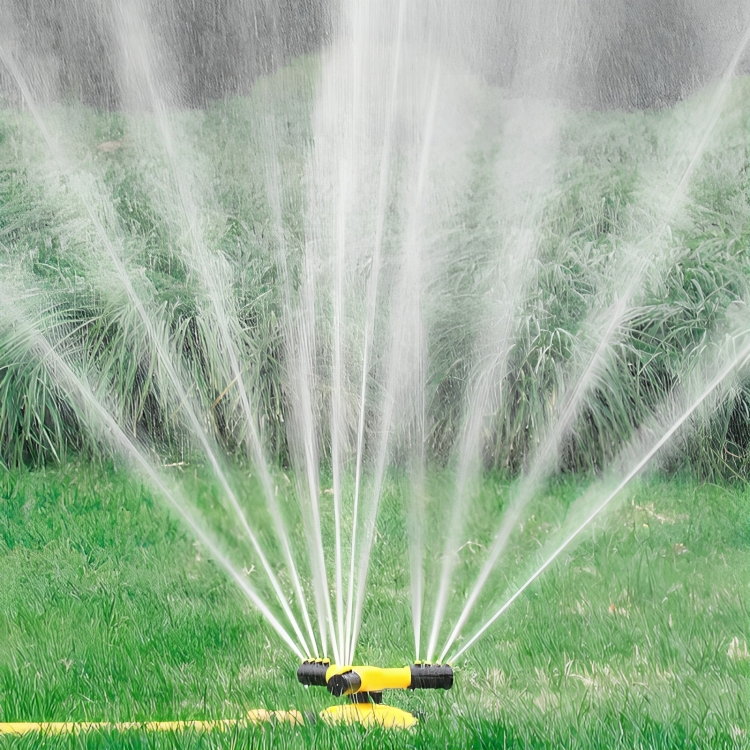 Rotating lawn sprinkler spraying water across green grass