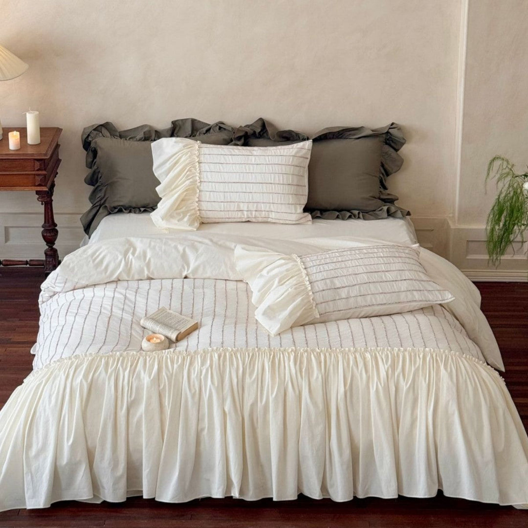 Ruffled bedding set styled on a bed with pillows and decorative skirt in a cozy bedroom