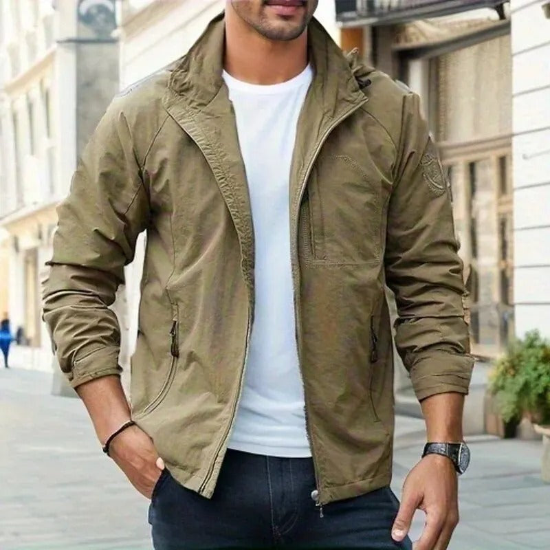 Man wearing a green hooded lightweight jacket outdoors