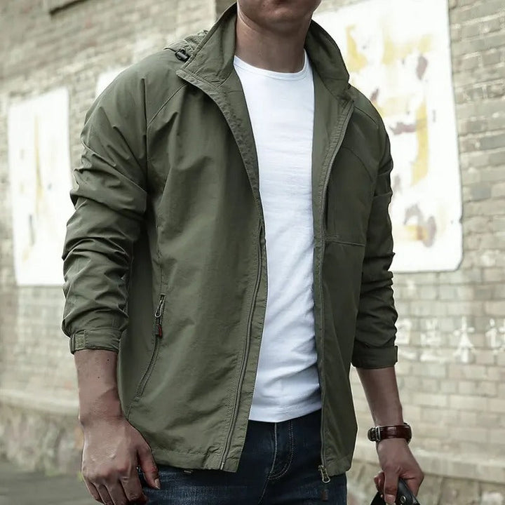 Man posing in a green casual hooded jacket on the street