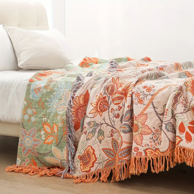 Rustic floral boho blanket draped over a white bed in a bright bedroom