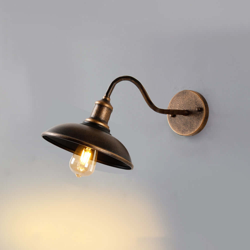 Antique brass rustic outdoor wall lamp illuminating a patio exterior wall