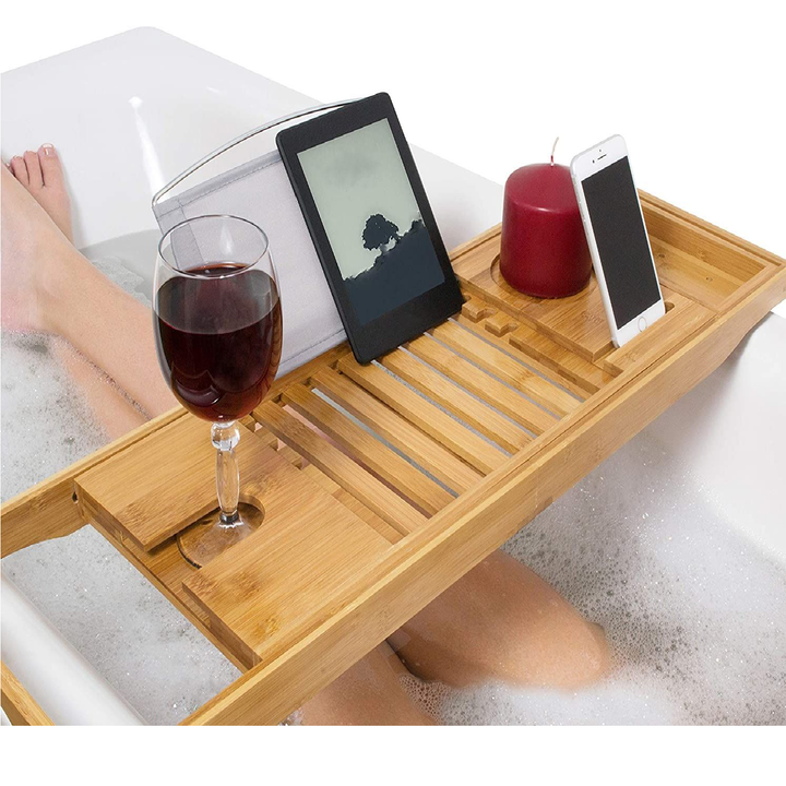 Top view of natural wood spa tray styled with bath accessories and candles