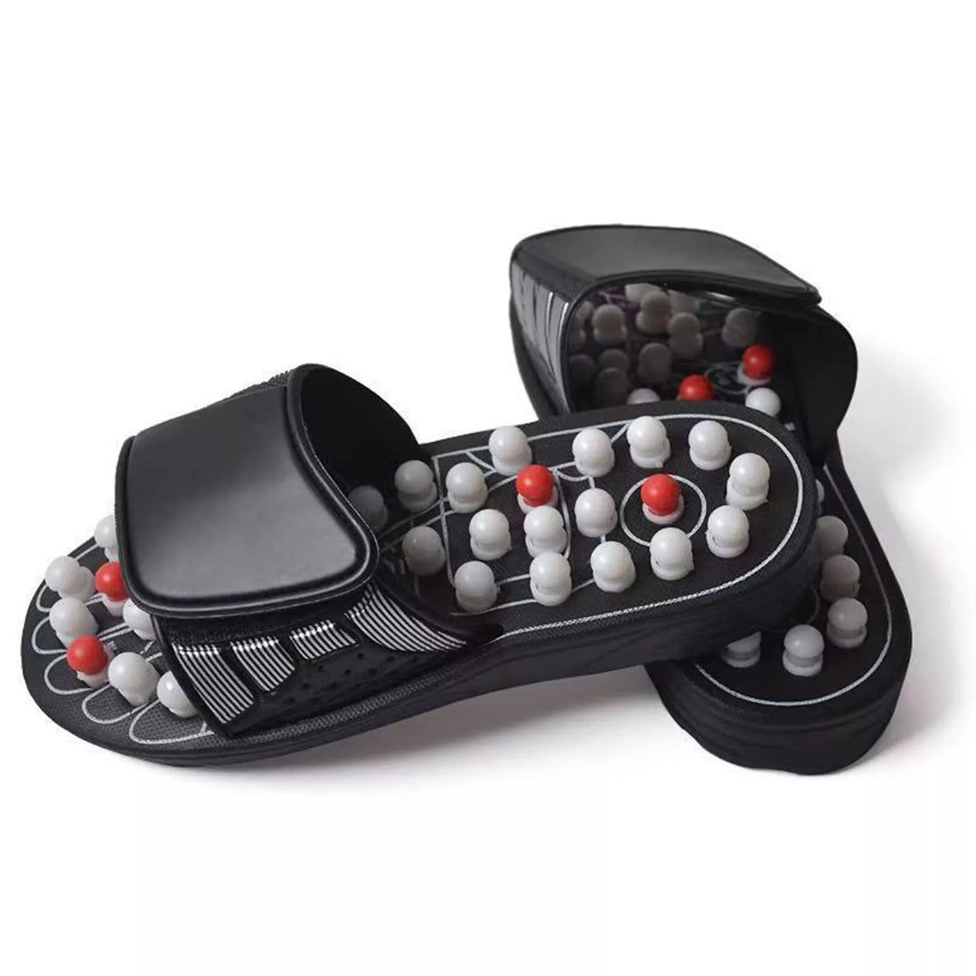 Pair of black acupressure sandals with rotating white and red nodes